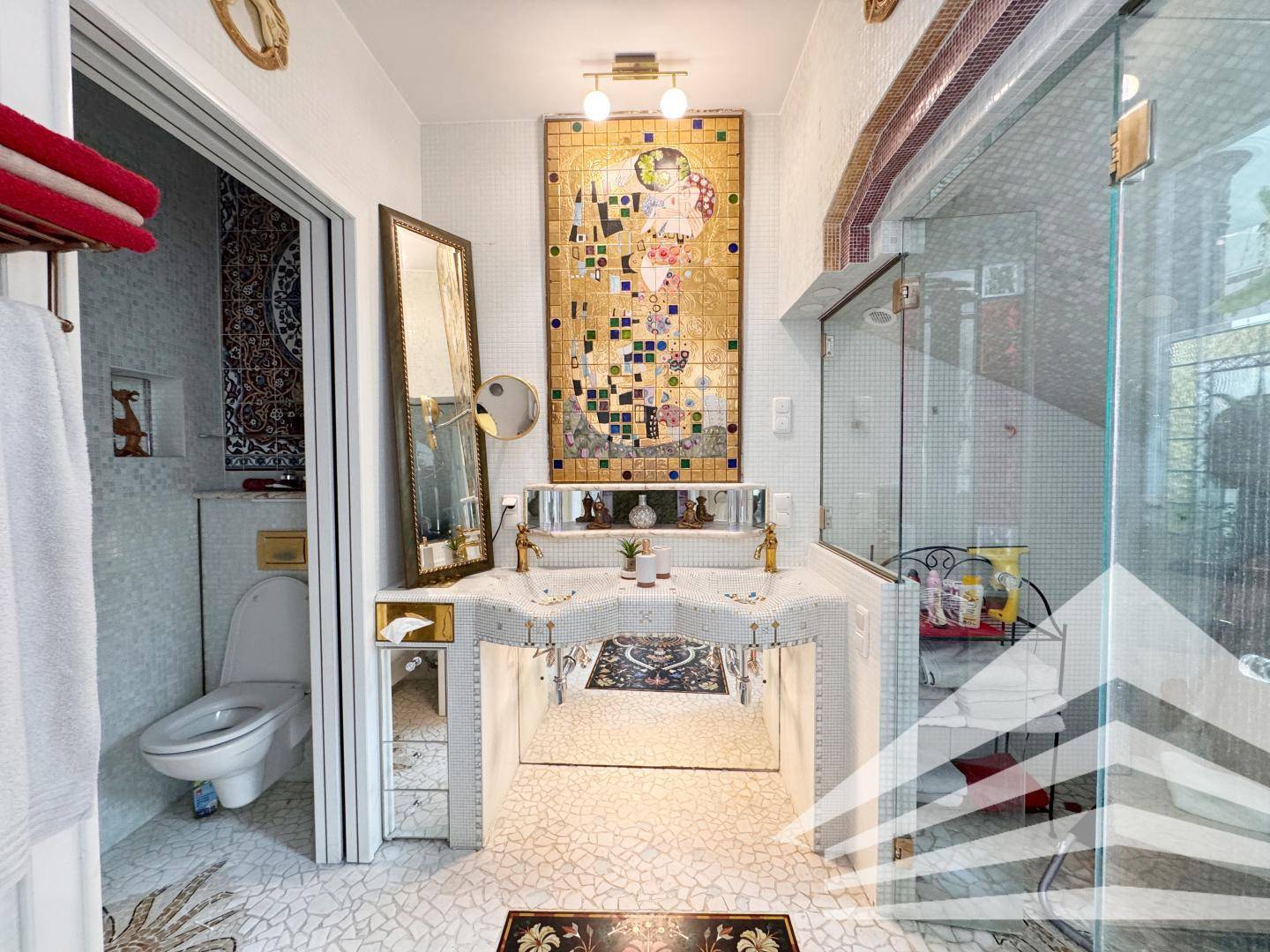 Modernes Badezimmer mit kunstvollem Mosaik, Doppelwaschbecken und begehbarer Dusche.