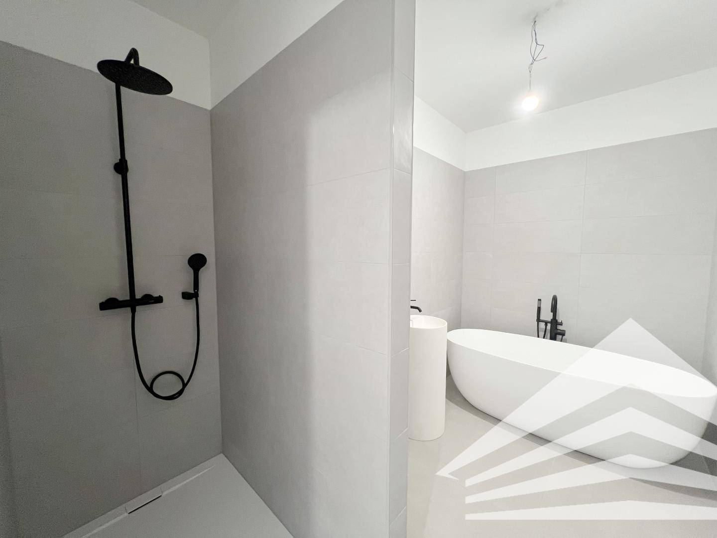 Elegantes Badezimmer mit begehbarer Dusche, Regendusche und freistehender Badewanne.