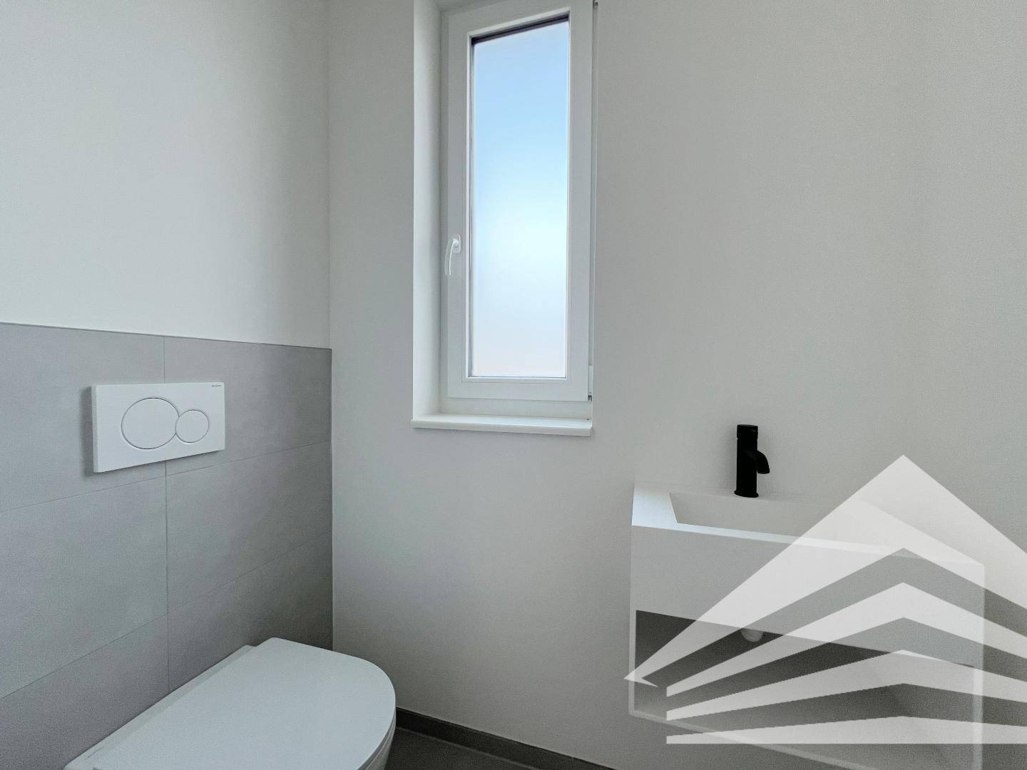 Modernes Gäste-WC mit wandhängender Toilette, kleinem Waschbecken und Fenster.