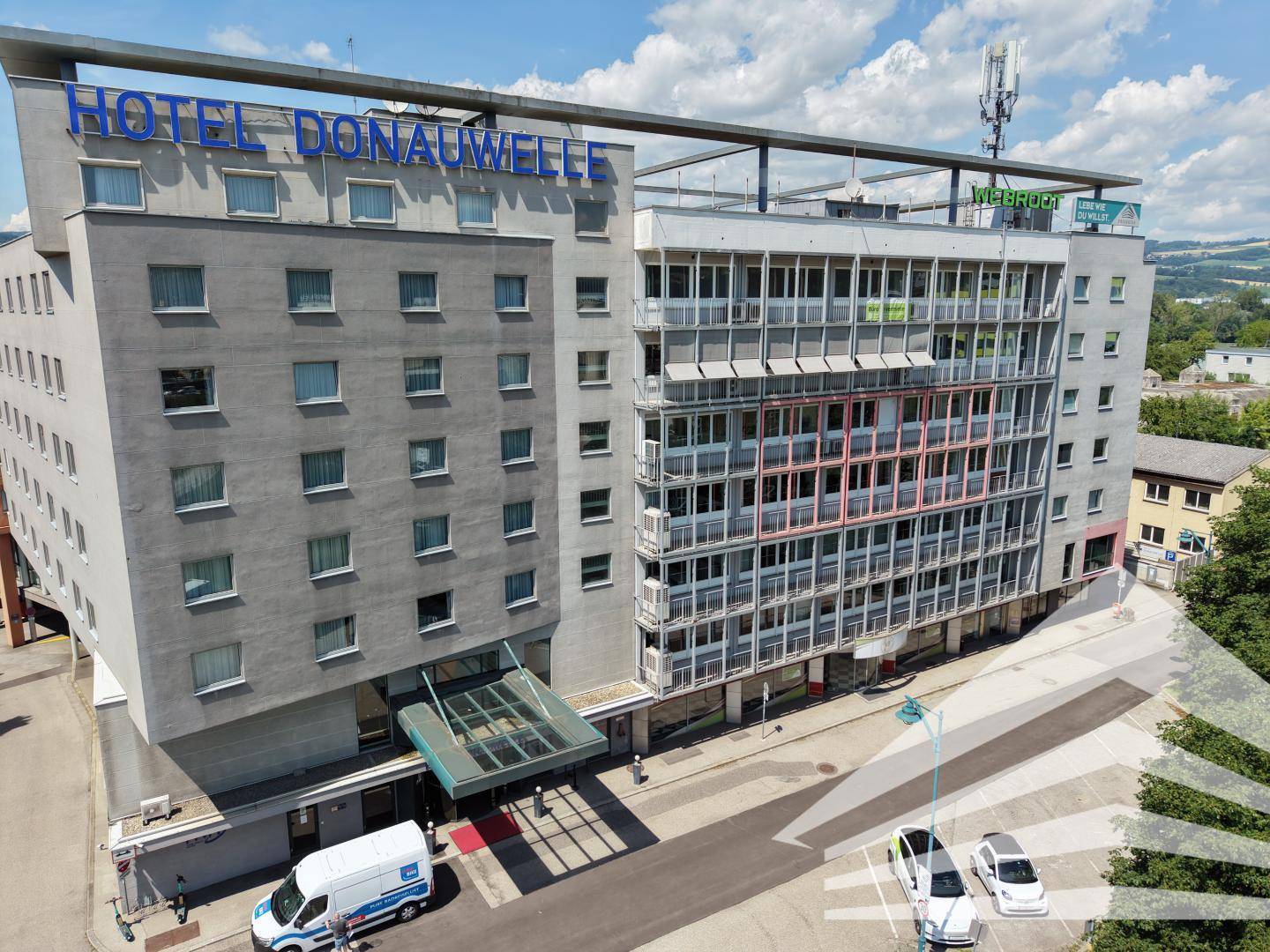Ansicht des Hotels Donauwelle von der Straße mit Eingangsbereich und moderner Fassade.