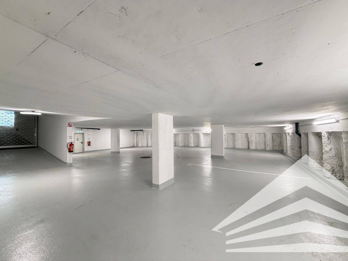 Geräumige Tiefgarage mit Betonboden und ausreichend Stellplätzen für Fahrzeuge.