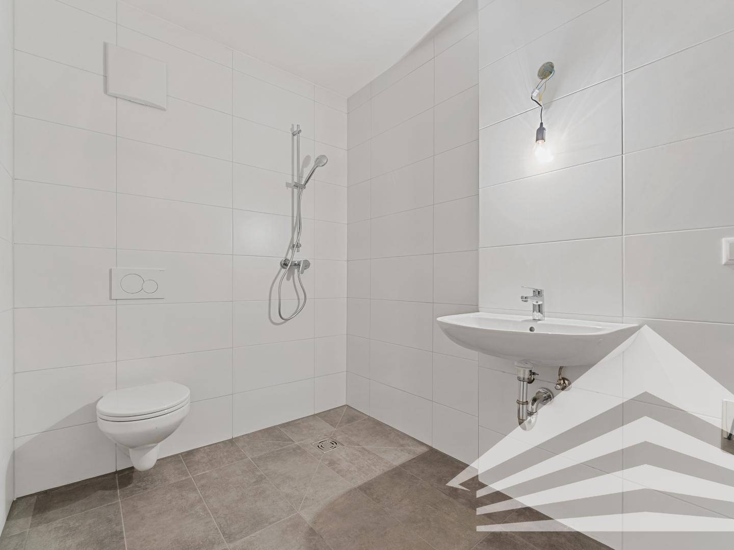 Modernes Badezimmer mit weißen Fliesen, bodengleicher Dusche und Wand-WC.
