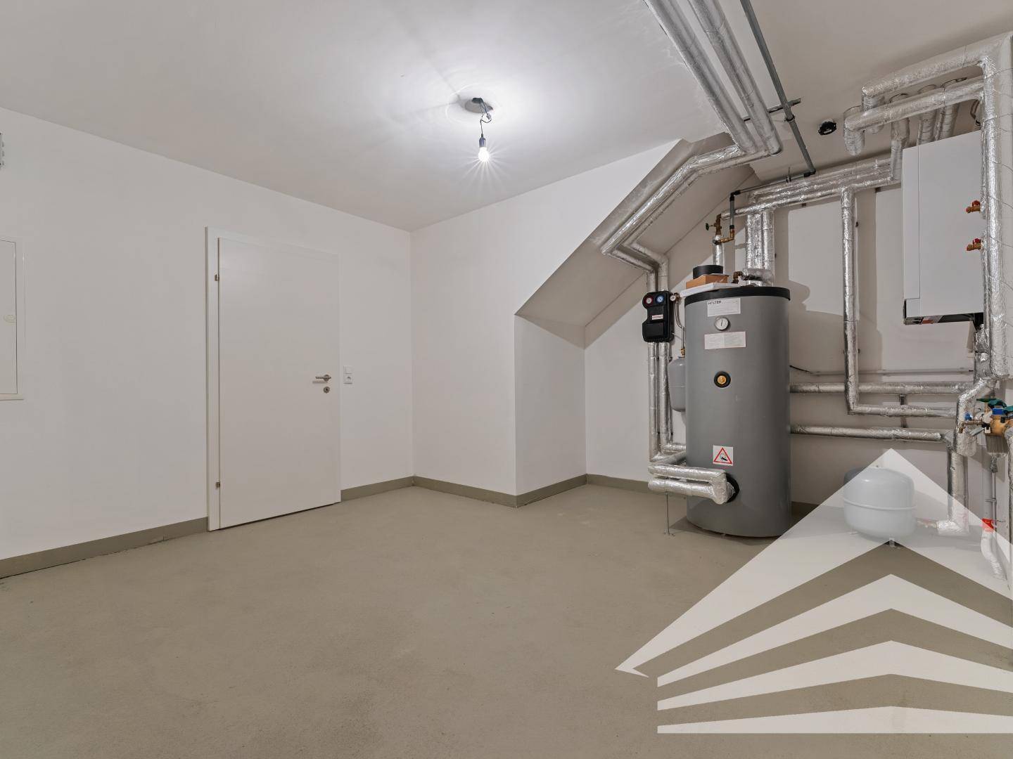 Technikraum im Untergeschoss mit Warmwasserbereiter und Heizungsanlage.