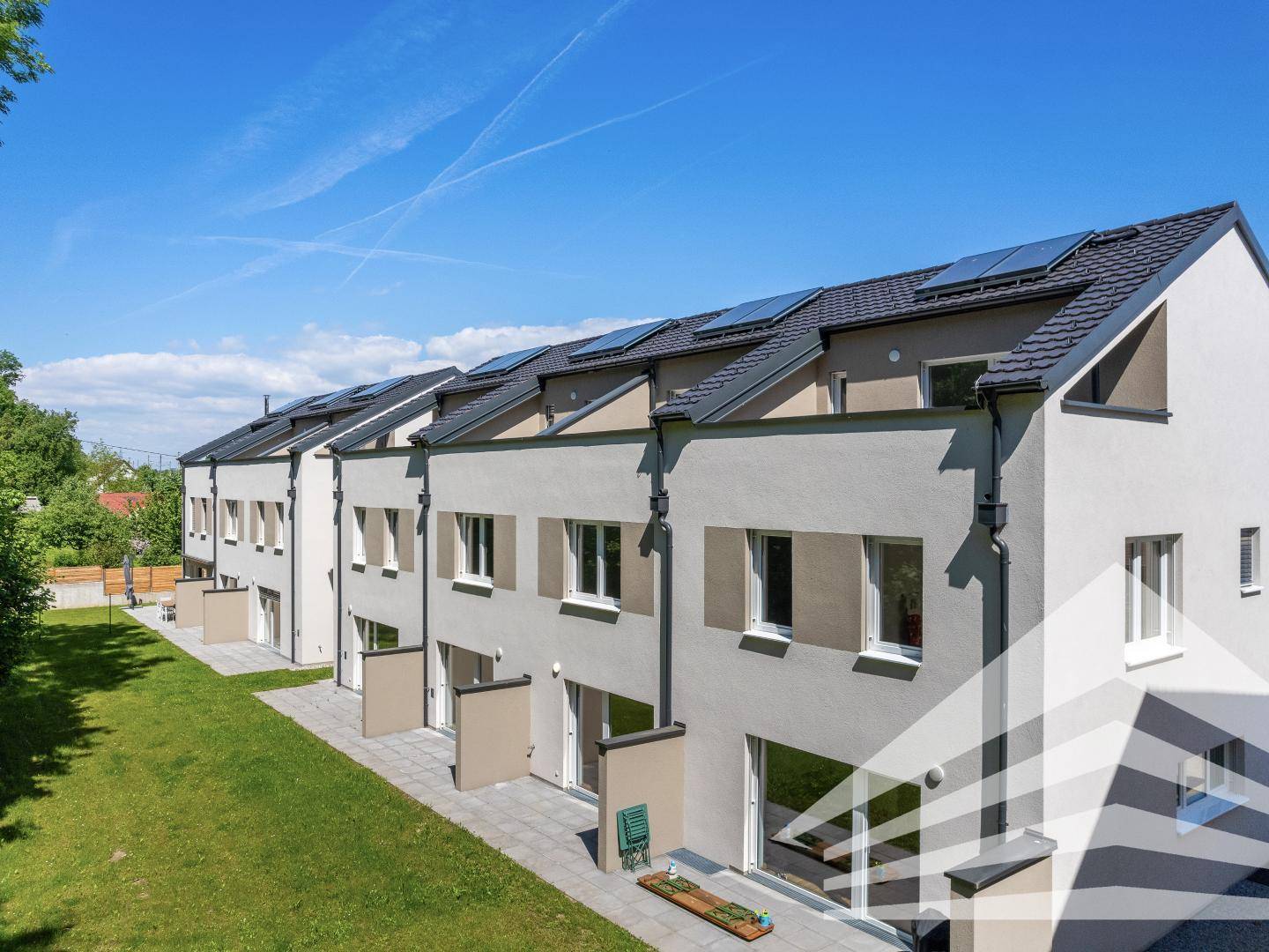 Rückseite der Reihenhäuser mit Terrassen, Gärten und Solaranlagen auf den Dächern.