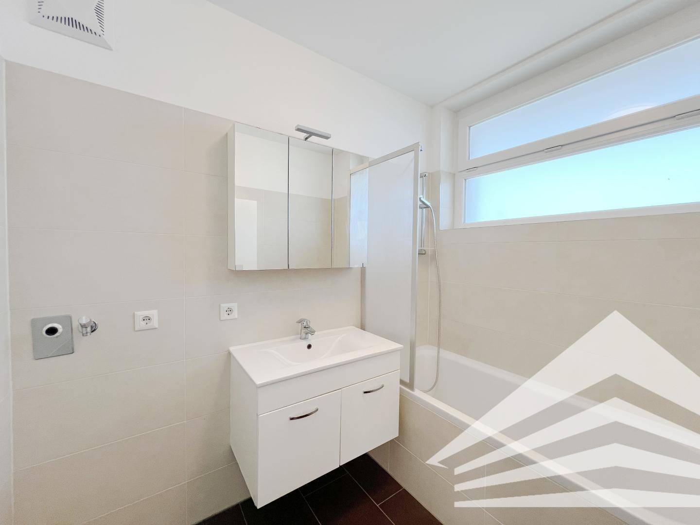 Modernes Badezimmer mit Badewanne, Einzelwaschbecken und einem Spiegelschrank über dem Waschtisch.