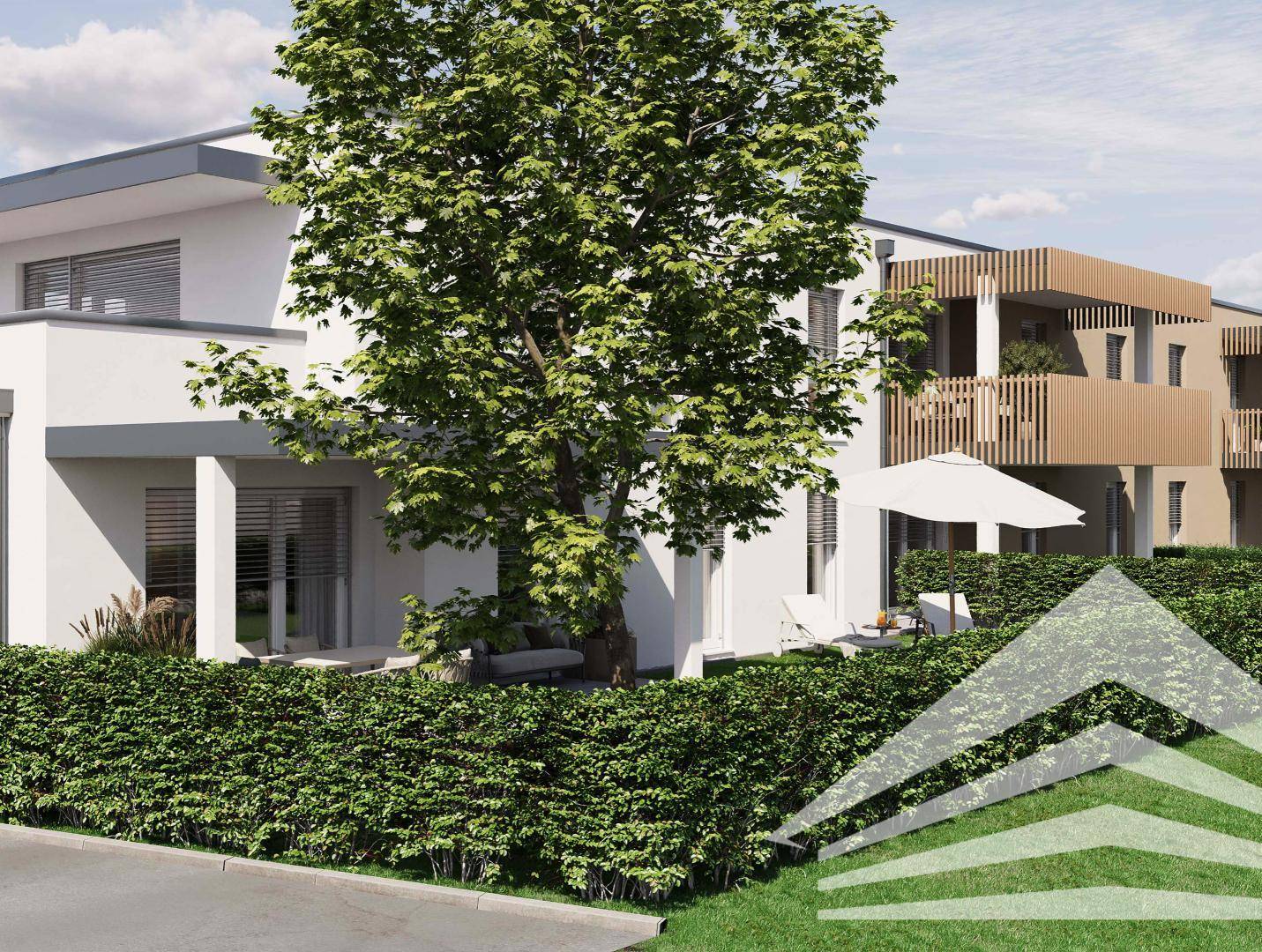 Seitenansicht der modernen Wohnanlage mit üppiger Hecke und schattenspendendem Baum.