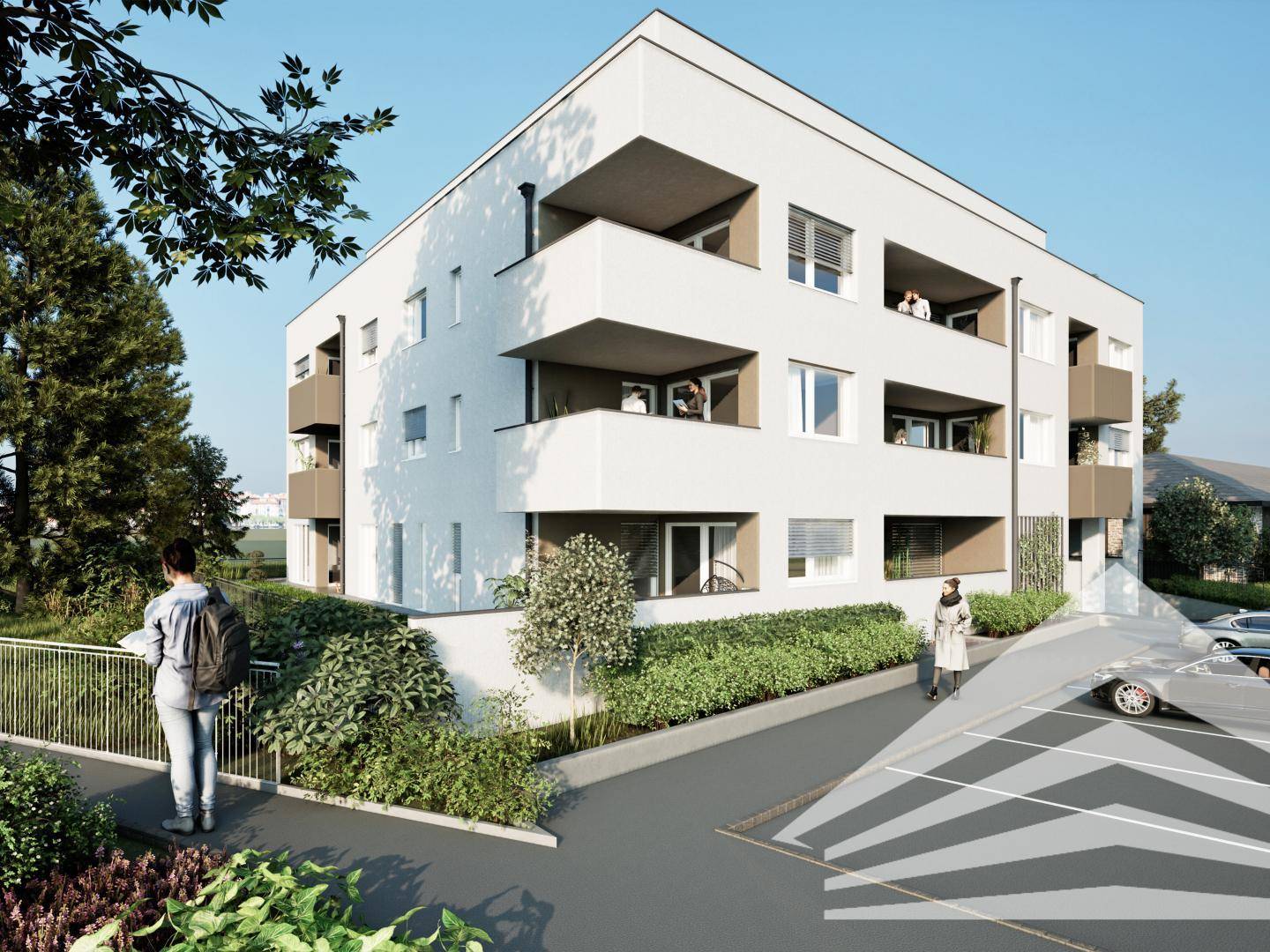 Moderne Wohnanlage von der Seite mit Grünflächen und Parkplätzen.
