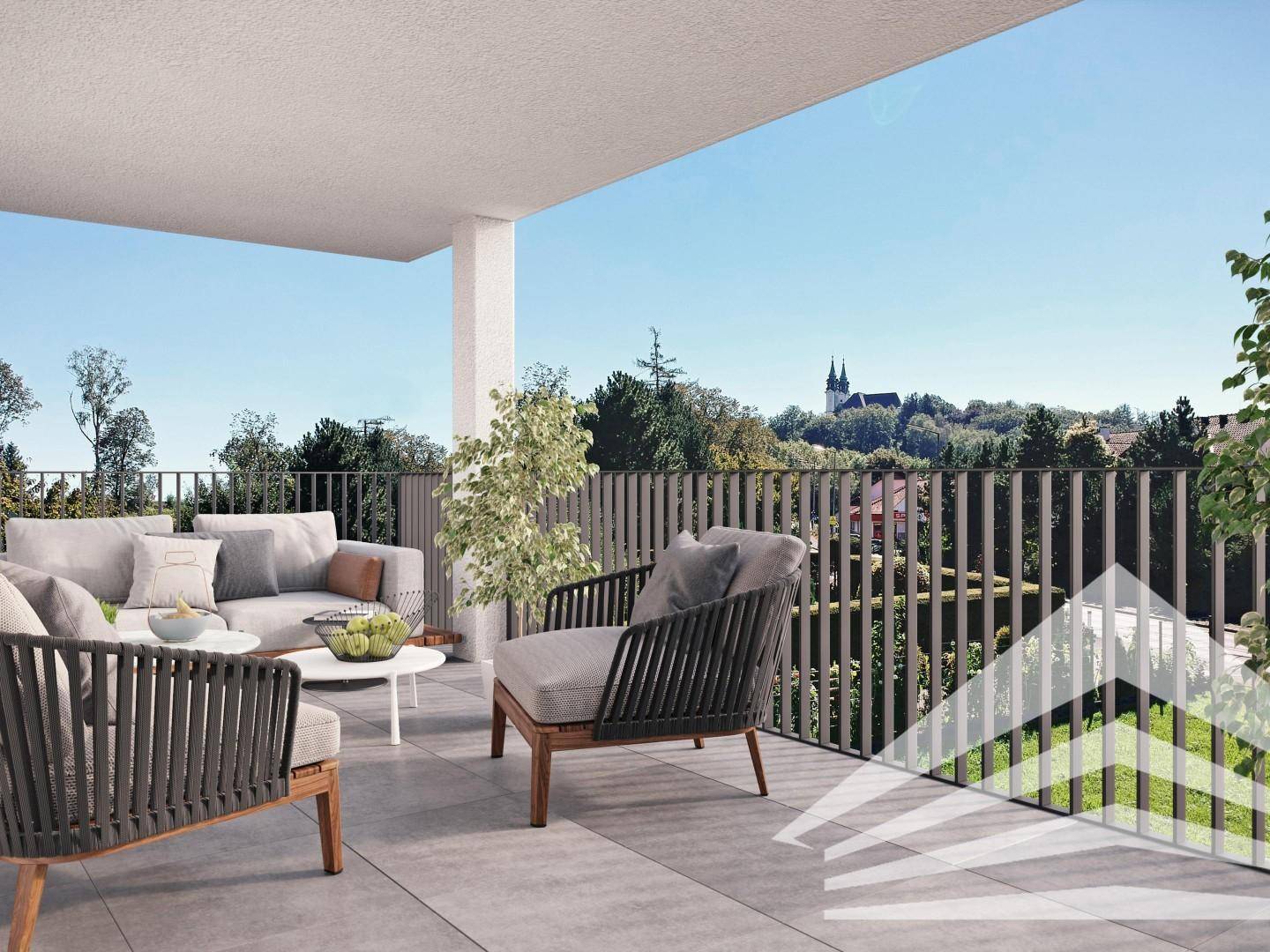 Möblierter Balkon mit Fliesenboden und Blick auf Bäume sowie eine Kirche auf dem Hügel.