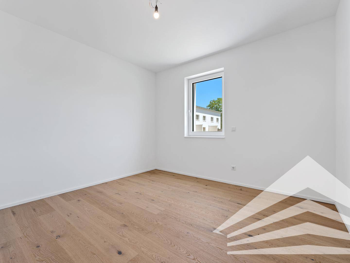 Leeres Zimmer mit Holzboden und Fenster, ideal als Schlaf- oder Arbeitszimmer nutzbar.
