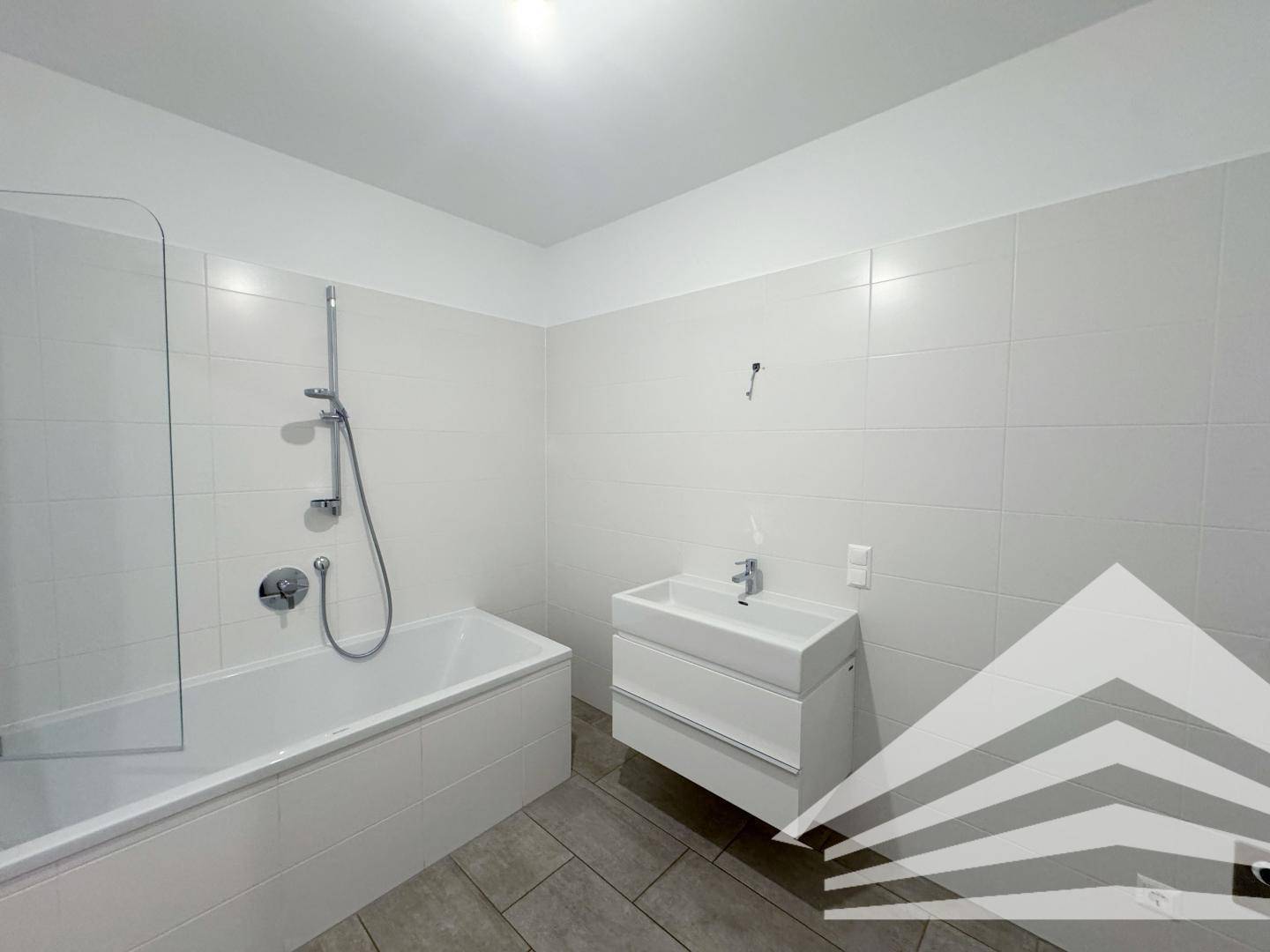 Modernes Badezimmer mit Badewanne, Duschabtrennung und schwebendem Waschtisch.