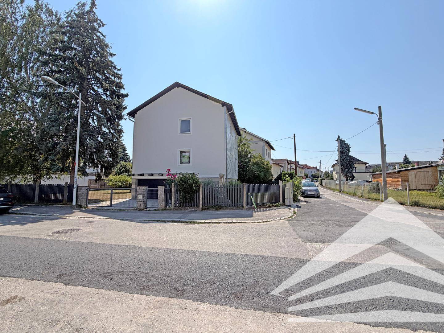 Außenansicht des Hauses von der Straße aus, mit Zufahrt und umliegender Wohnbebauung.