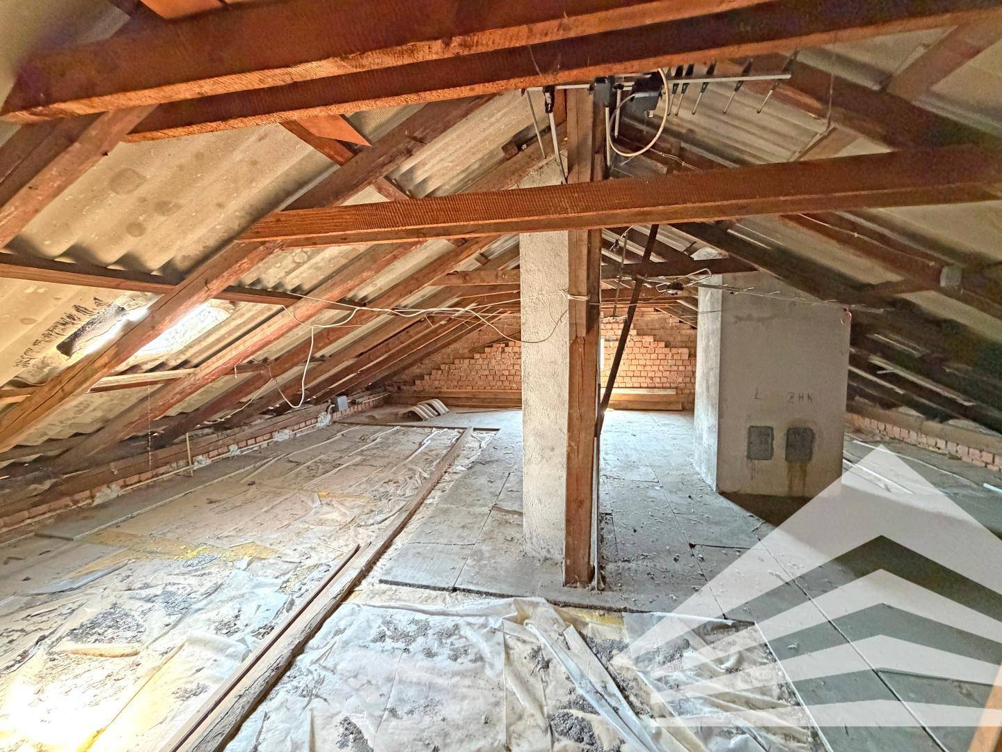 Unausgebauter Dachboden mit sichtbaren Holzbalken und Dachkonstruktion, bietet Potenzial für zukünftigen Ausbau.