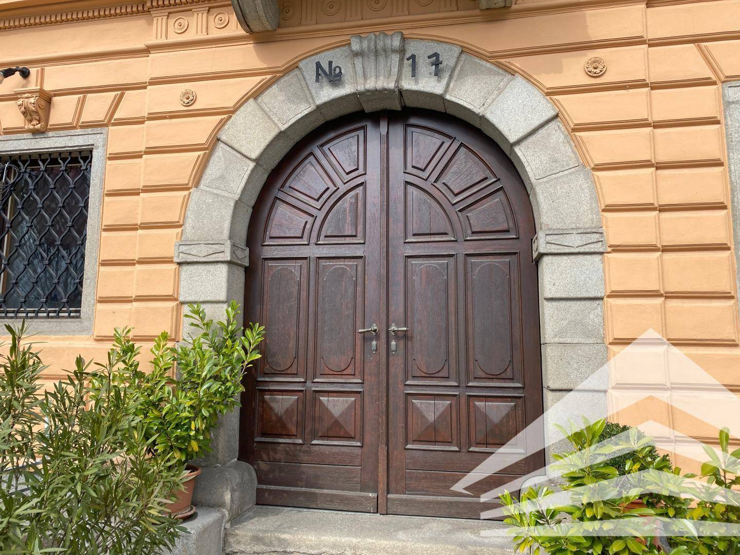 Detailansicht eines historischen Holztors mit Steinrahmen und der Hausnummer 17.