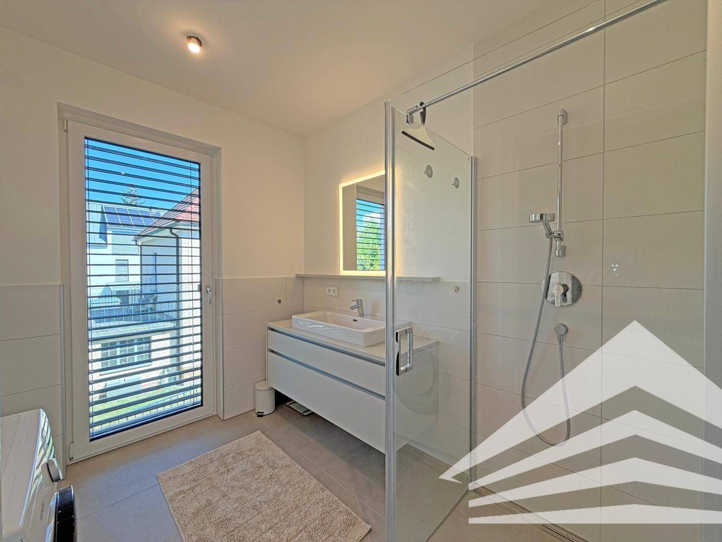 Modernes Badezimmer mit ebenerdiger Dusche, Einzelwaschbecken und großem Fenster.