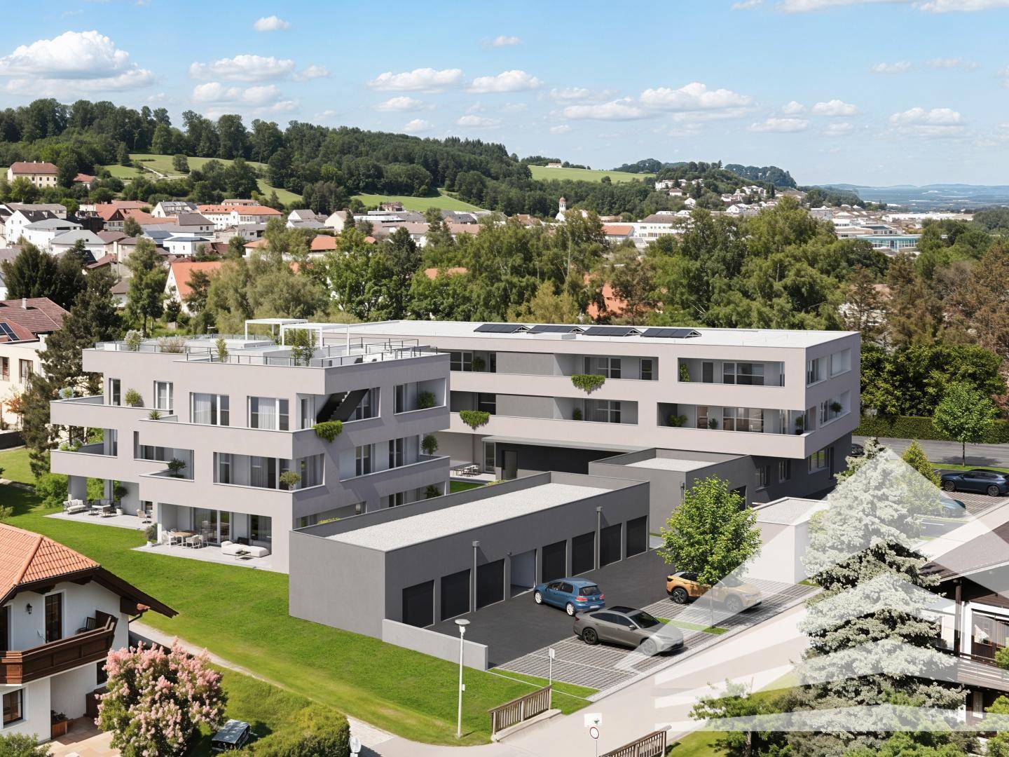 Luftaufnahme einer modernen Wohnanlage mit Tiefgarage und umliegender grüner Landschaft.