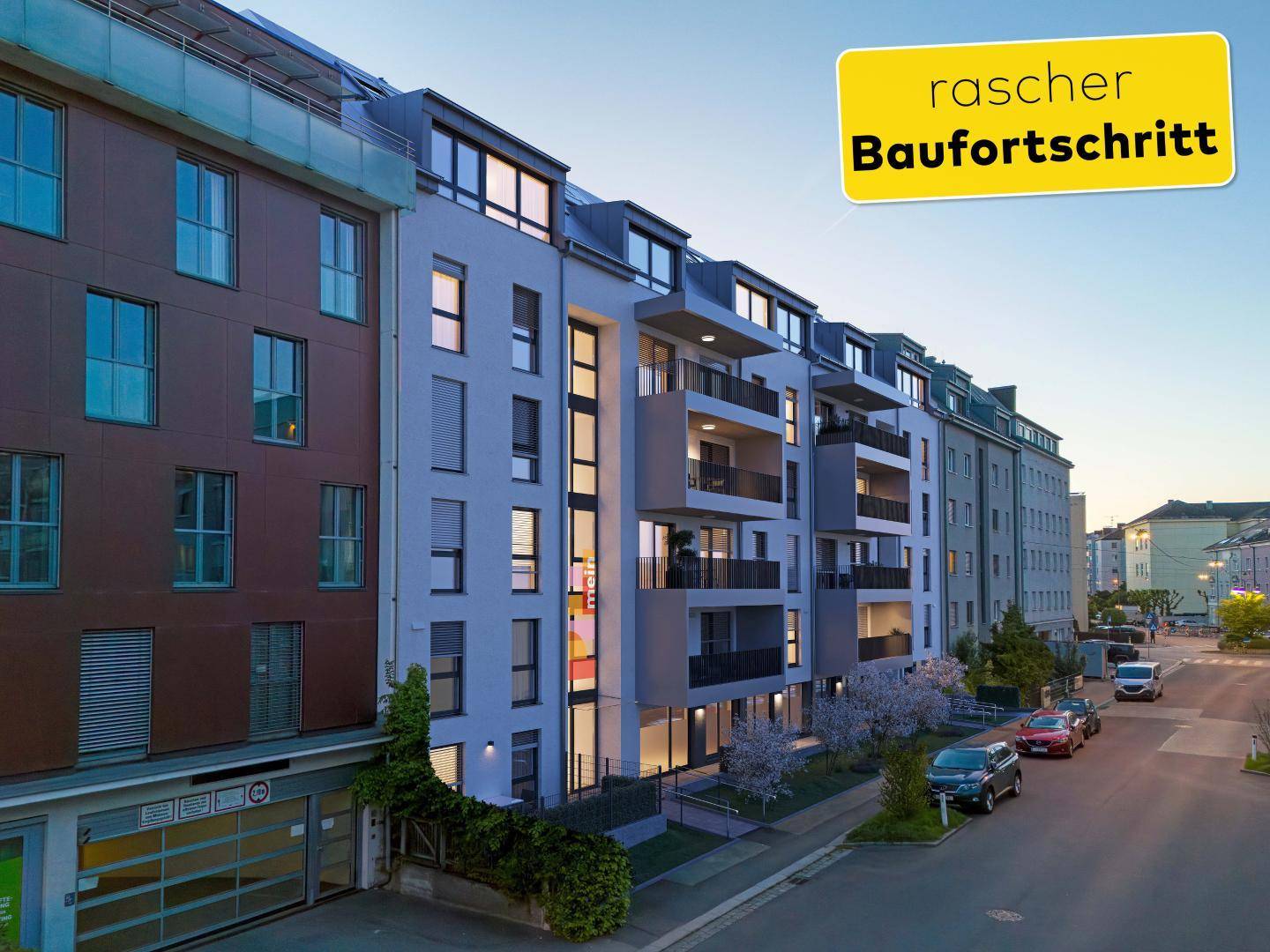 Moderne Wohnhausfassade bei Dämmerung mit beleuchteten Balkonen und Fenstern.