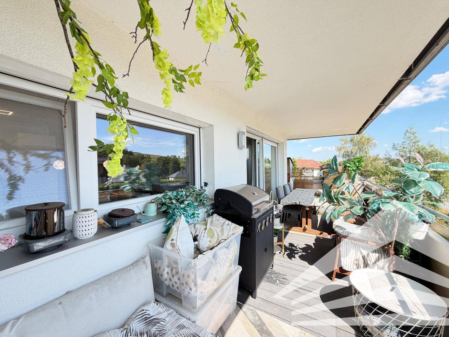 Großer Balkon mit Grill und Pflanzen, ideal für entspannte Stunden im Freien mit Weitblick.