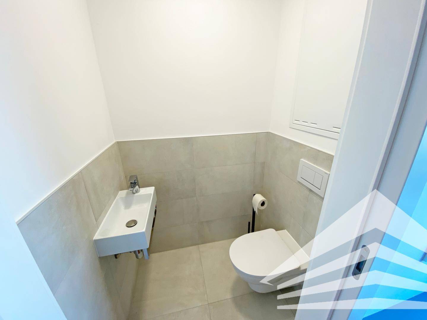 Kleines, modernes Gäste-WC mit wandhängender Toilette und minimalistischem Waschbecken.