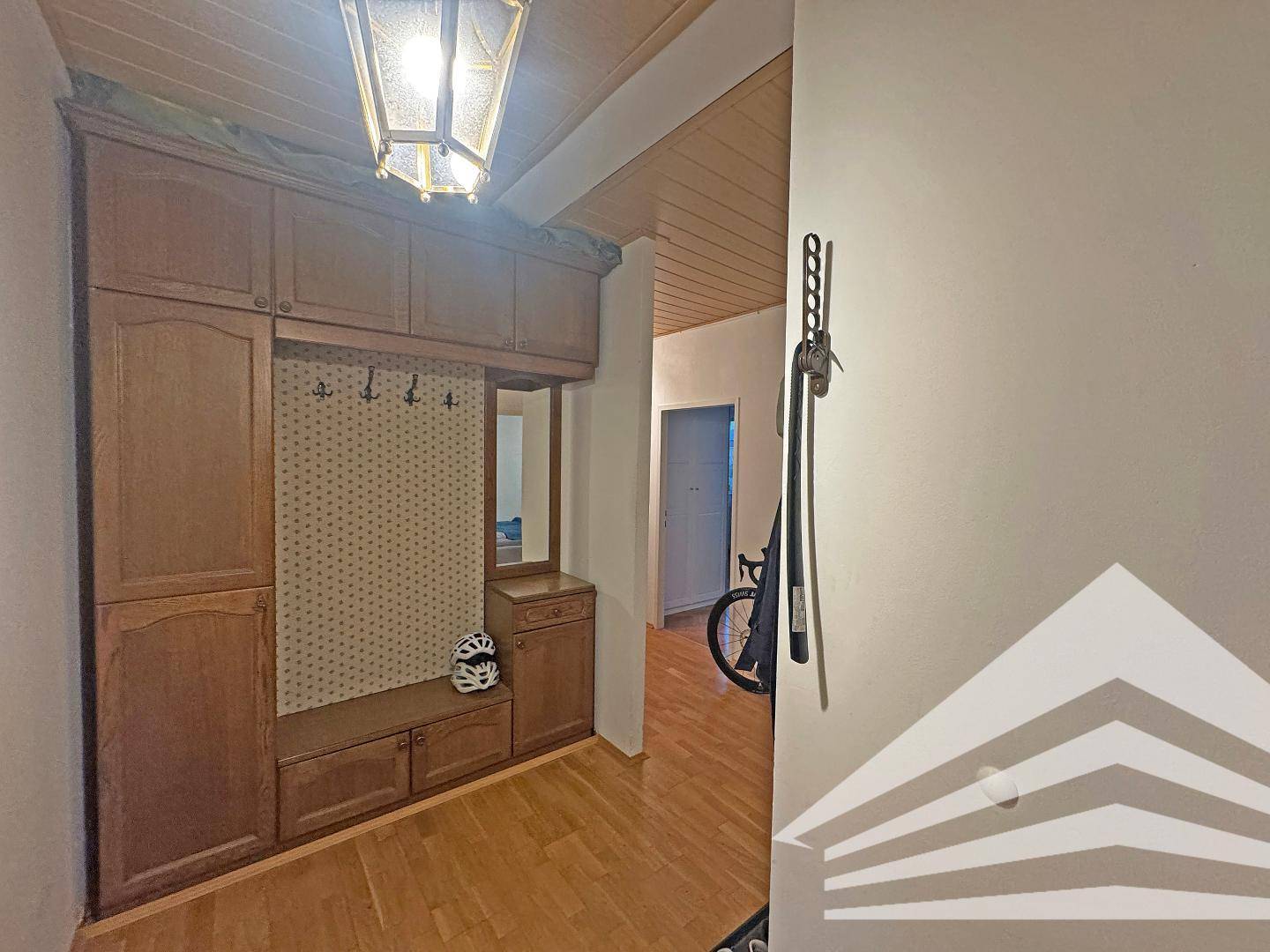 Flur mit Holzdecke und integrierter Garderobe, die viel Stauraum bietet.