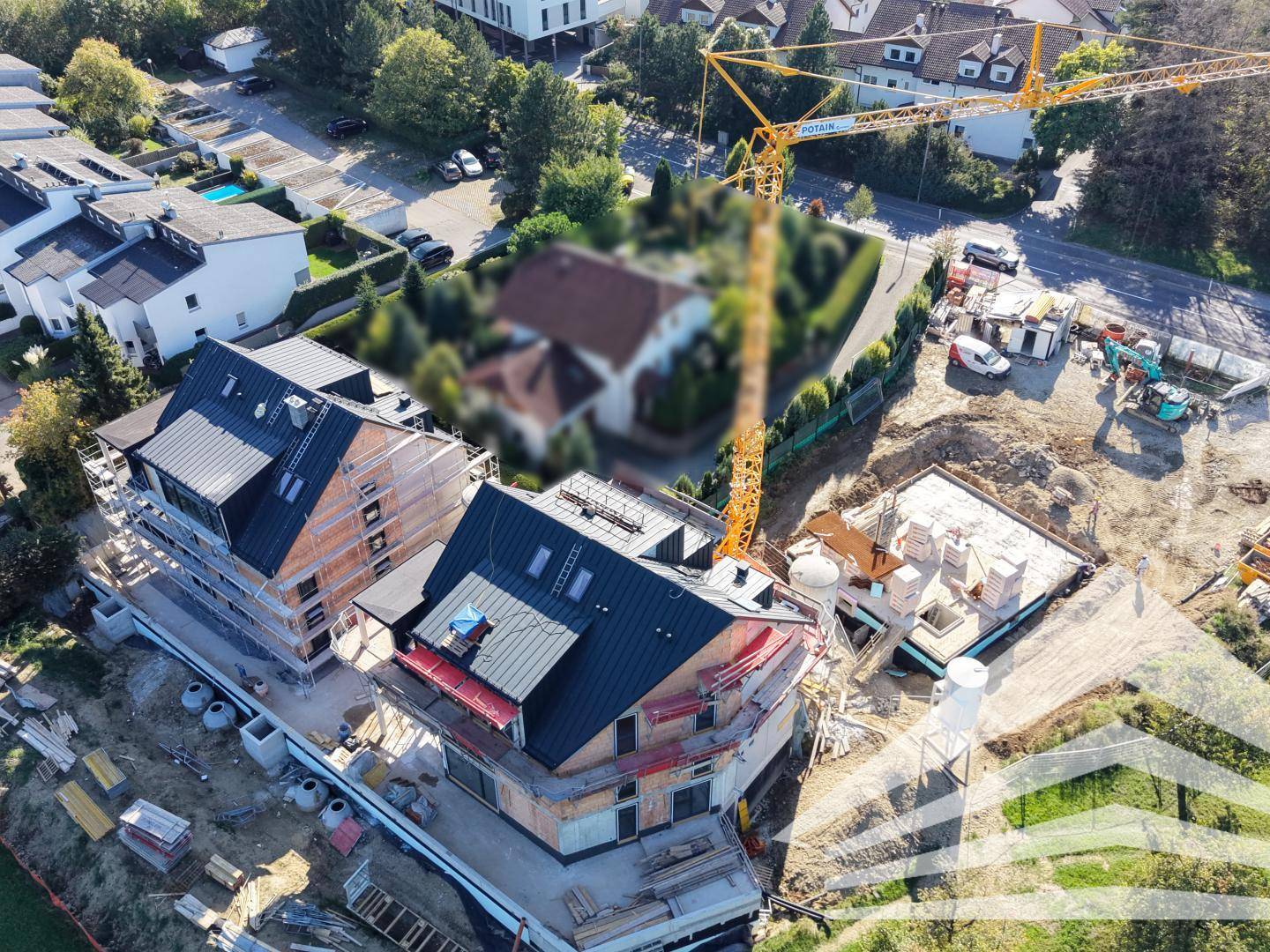 Drohnenansicht einer Baustelle mit einem im Bau befindlichen Gebäude und einem Kran.