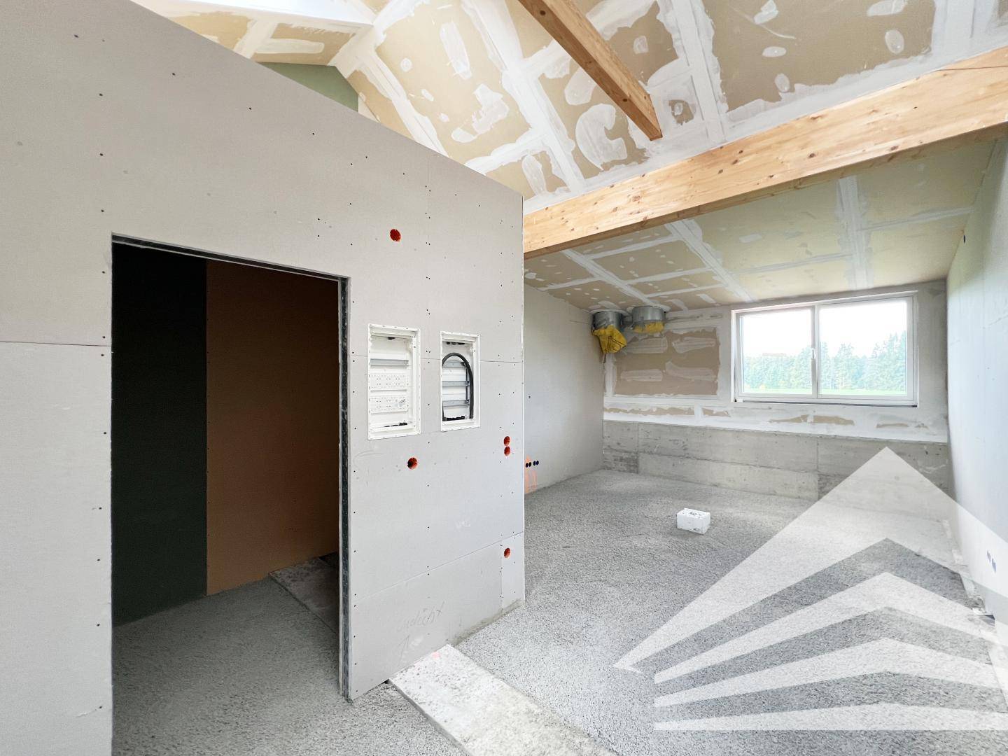 Unfertiger Raum mit sichtbaren Elektroinstallationen, Trockenbauwänden und einem Fenster mit Ausblick.