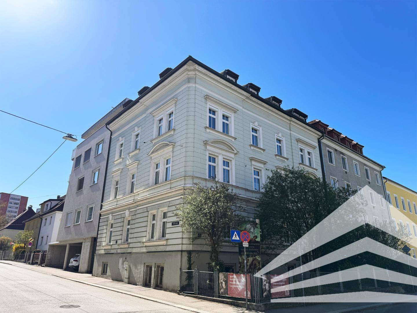 Historisches Gebäude mit klassischer Fassade, vielen Fenstern und blauer Himmelskulisse.