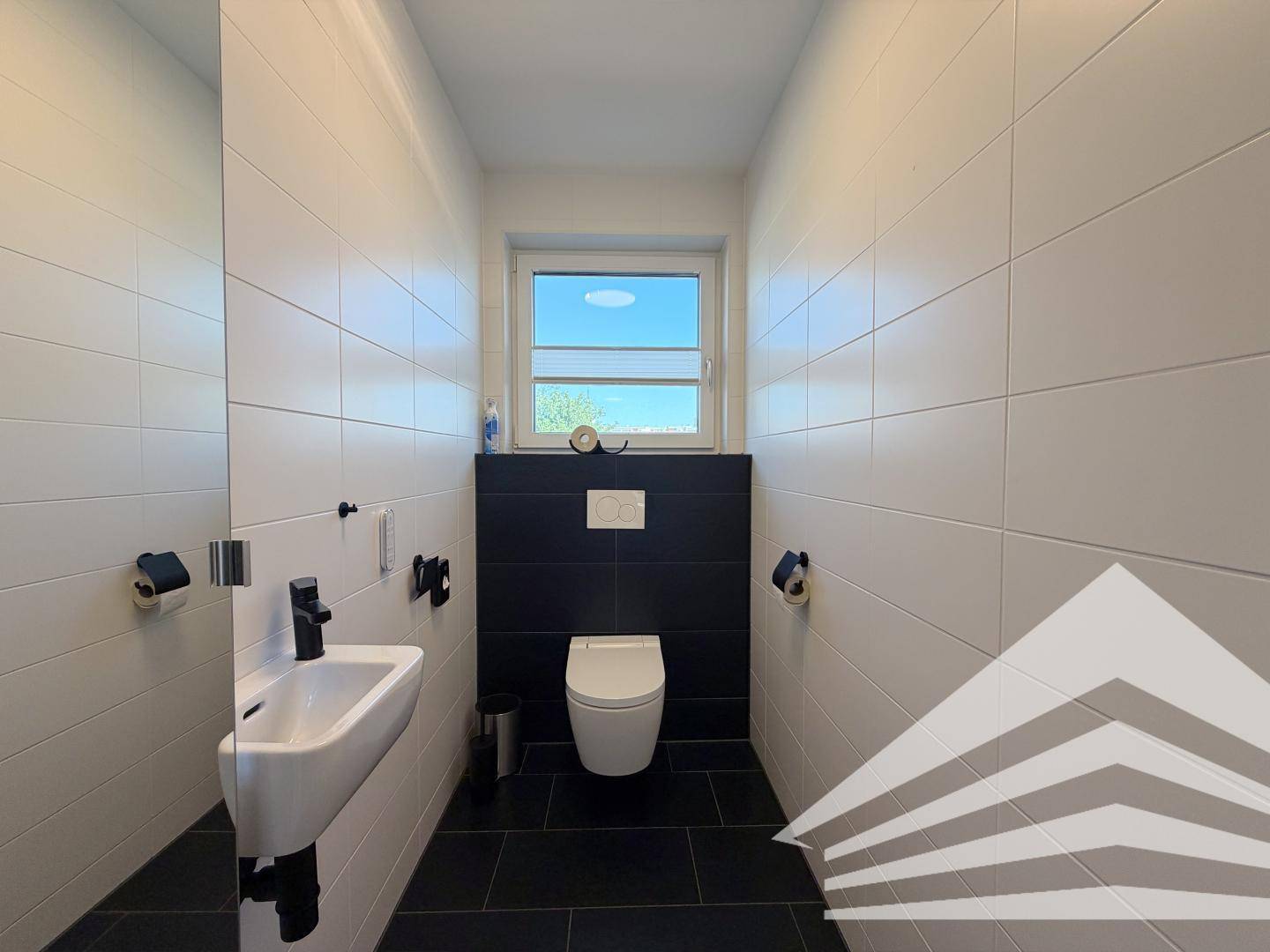 Modernes Gäste-WC mit Fenster, Wand-WC und kleinem Waschbecken.