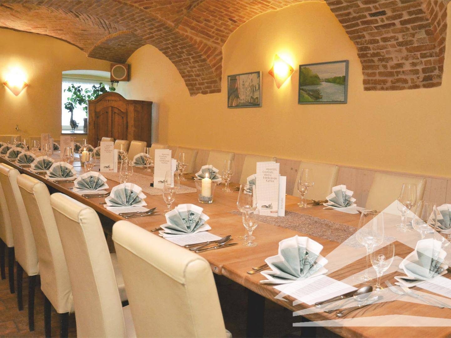 Langer Speisesaal mit beeindruckenden Ziegelgewölbedecken und elegant gedeckten Tischen.