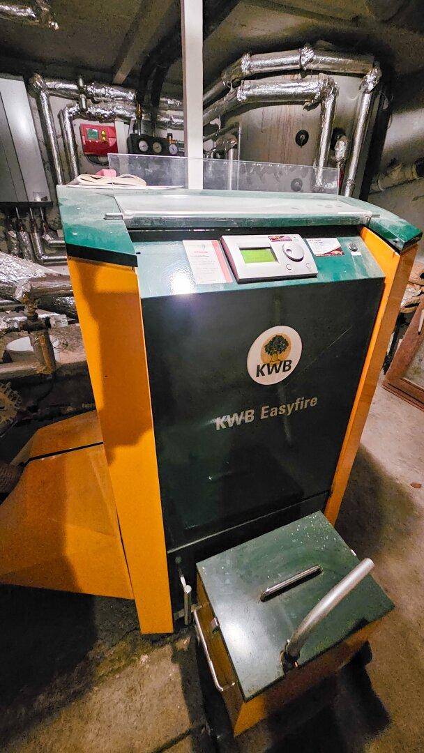 Heizungsraum im Keller mit einem KWB Easyfire Pelletkessel und Rohrleitungen.