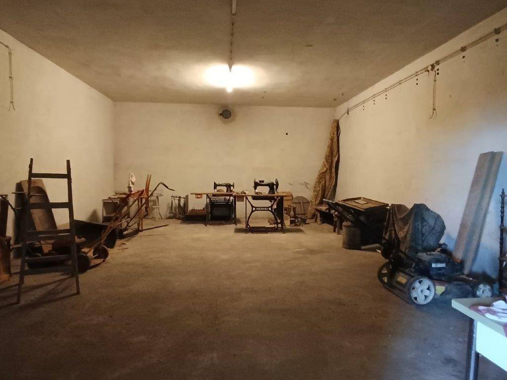 Geräumiger Kellerraum mit Betonboden und weißen Wänden, der als Lager- oder Arbeitsbereich dient.