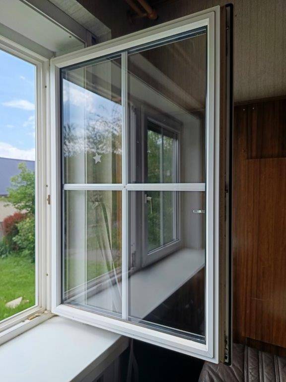 Geöffnetes Fenster mit Blick auf den Garten und den blauen Himmel, lässt viel Licht herein.