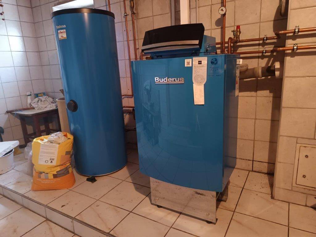Heizungsraum mit einem modernen Buderus Heizkessel und Warmwasserspeicher.