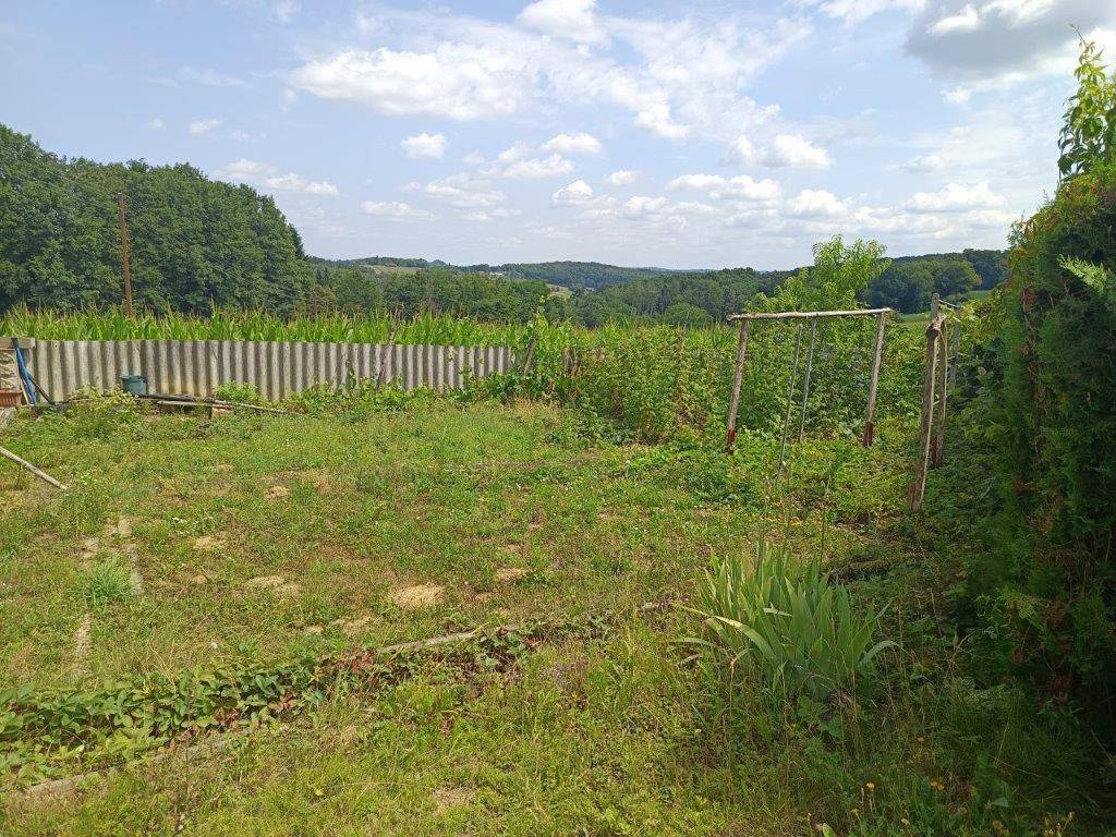 Hinterhof mit Rasenfläche, Schaukelgestell und weitem Blick auf die umliegende Landschaft.