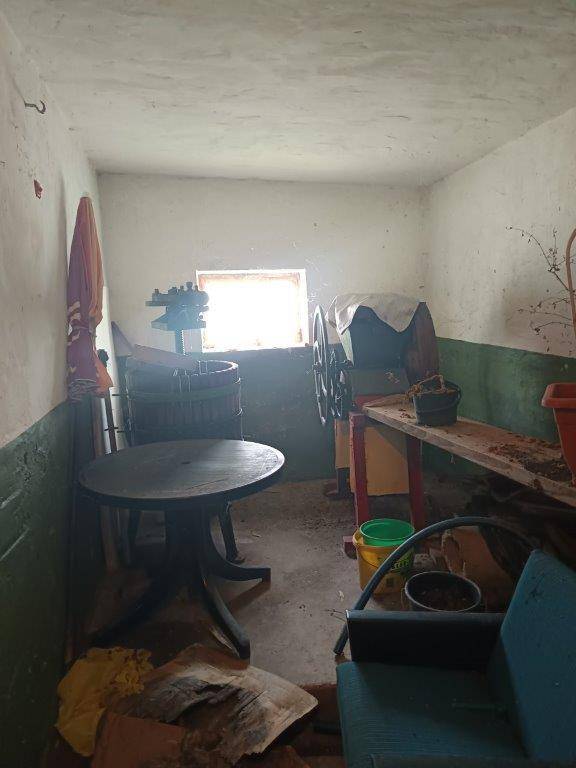 Kellerraum mit kleinem Fenster, alten Möbeln und einer rustikalen Einrichtung.