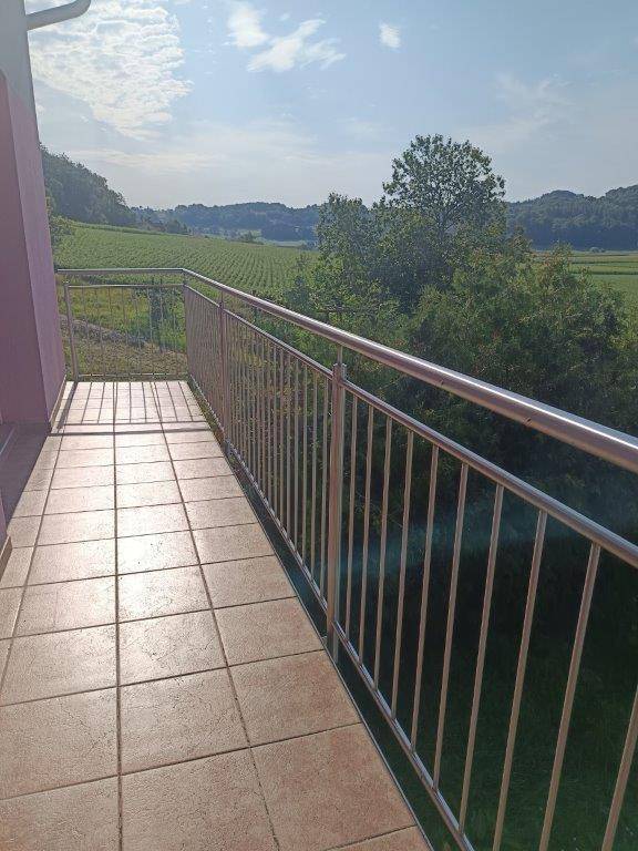 Balkon mit Fliesenboden und Metallgeländer, bietet einen weiten Blick auf die Landschaft.