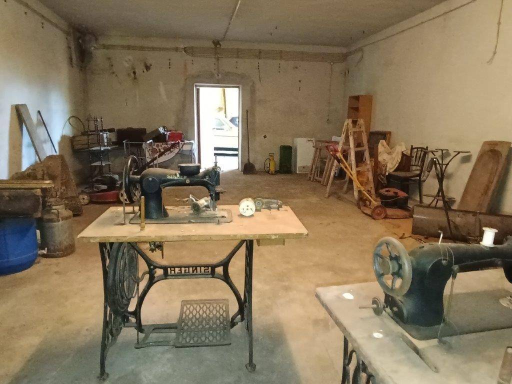 Kellerraum mit alten Nähmaschinen und verschiedenen Gegenständen, der als Werkstatt oder Lager genutzt wird.