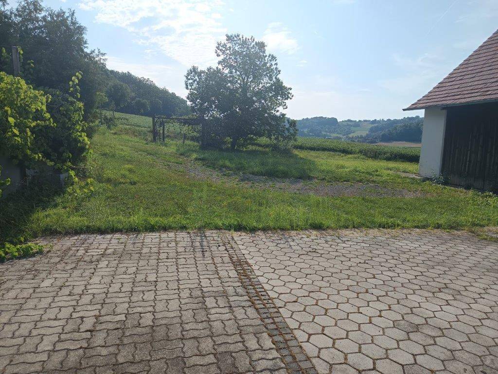 Großer gepflasterter Bereich vor dem Gebäude mit weitem Blick auf die Landschaft.