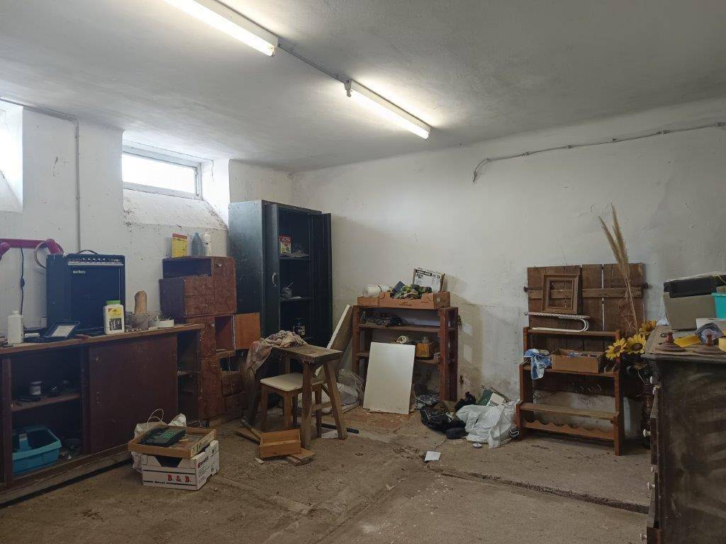 Geräumiger Werkstattraum im Untergeschoss mit kleinen Fenstern und funktionaler Beleuchtung, ideal für handwerkliche Arbeiten.