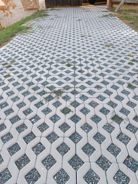 Detailansicht der gepflasterten Zufahrt mit einem dekorativen Muster aus Betonsteinen und Kies.