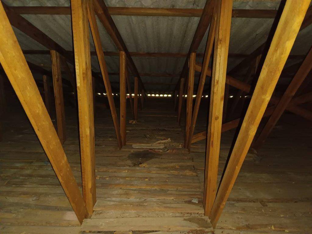 Unausgebauter Dachboden mit sichtbaren Holzsparren und Dachkonstruktion, der Ausbaupotenzial bietet.