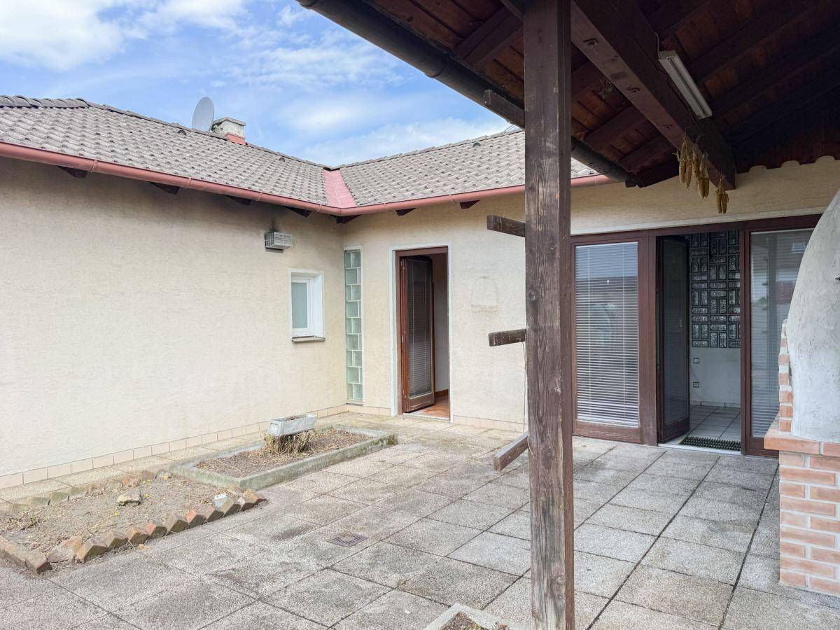 Geräumige Terrasse mit Überdachung und Zugang zum Haus, ideal für Entspannung im Freien.