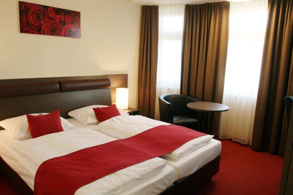 Komfortables Schlafzimmer mit zwei Einzelbetten, rotem Teppichboden und braunen Vorhängen.