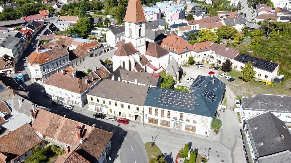 Weitläufige Luftaufnahme eines historischen Stadtzentrums mit Kirche und umliegenden Gebäuden.