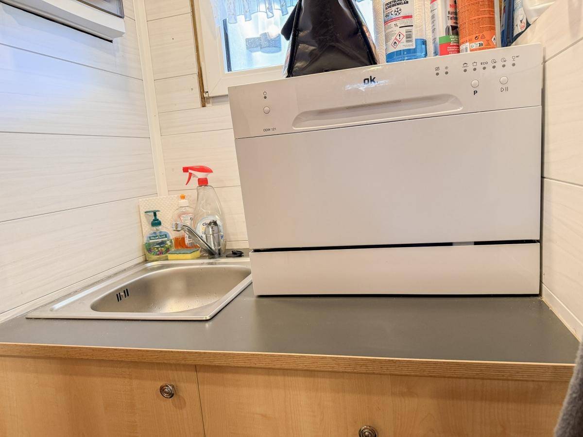 Funktionale Küchenzeile mit Spülbecken und einem kompakten Geschirrspüler in hellem Ambiente.