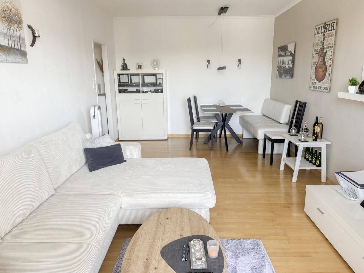 Geräumiger Wohnbereich mit L-förmigem Sofa, Esstisch und modernem Dekor.