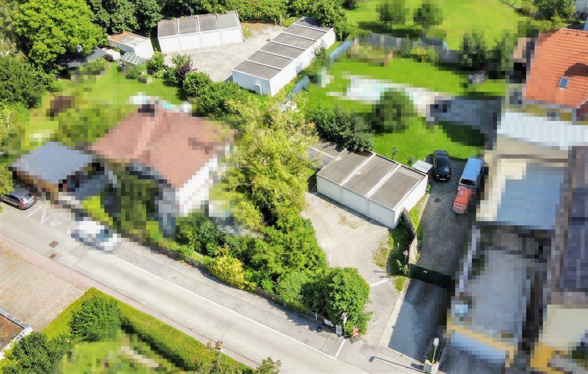 Übersicht aus der Vogelperspektive mit Wohnhaus, Garagen und weitläufigen Grünflächen.