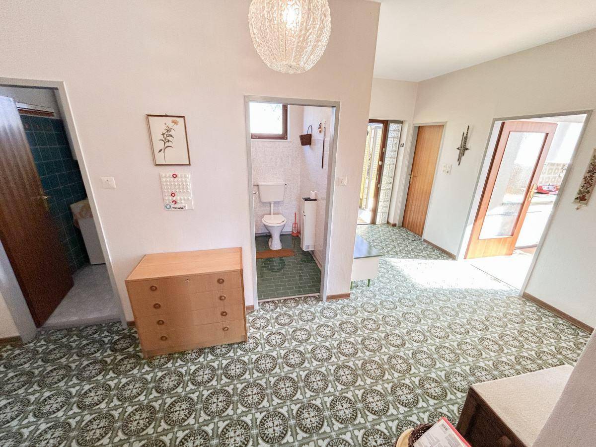 Heller Flur mit Zugang zu Badezimmer und separatem WC.