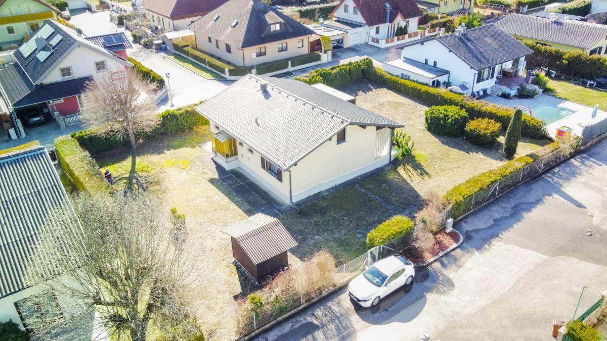 Luftaufnahme des Einfamilienhauses mit Garten und umliegenden Häusern in einer ruhigen Gegend.