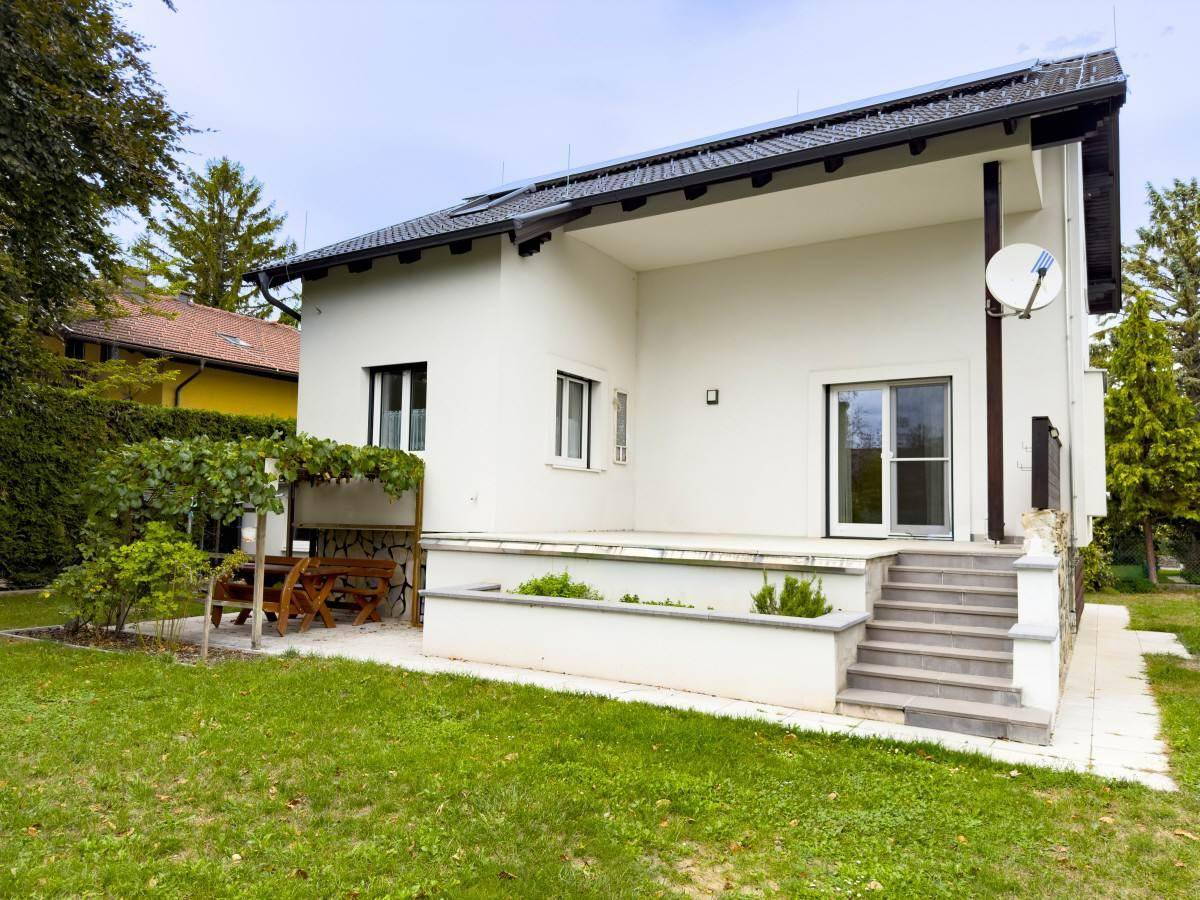 Geräumige Terrasse mit Treppe zum Garten und Blick auf die grüne Umgebung.