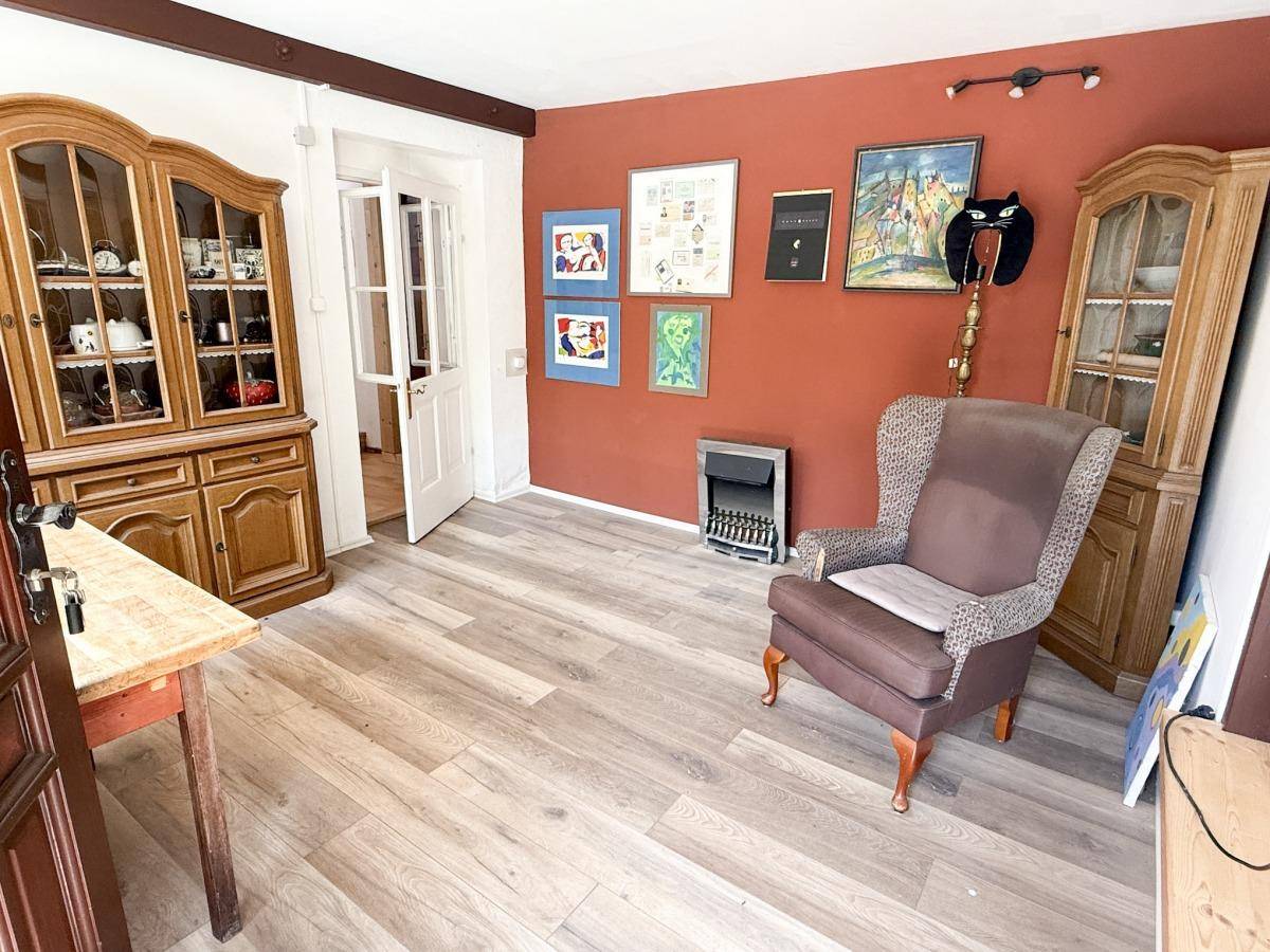 Gemütlicher Raum mit Laminatboden, roten Wänden und traditionellen Holzschränken.